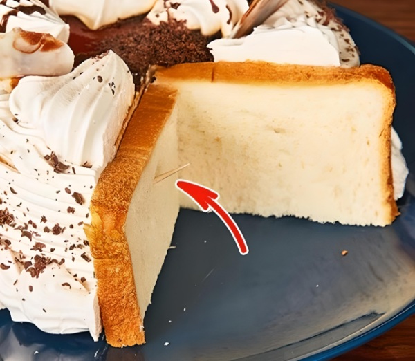 D&ugrave;ng b&aacute;nh m&igrave; sandwich bọc phần b&aacute;nh kem vừa cắt dở